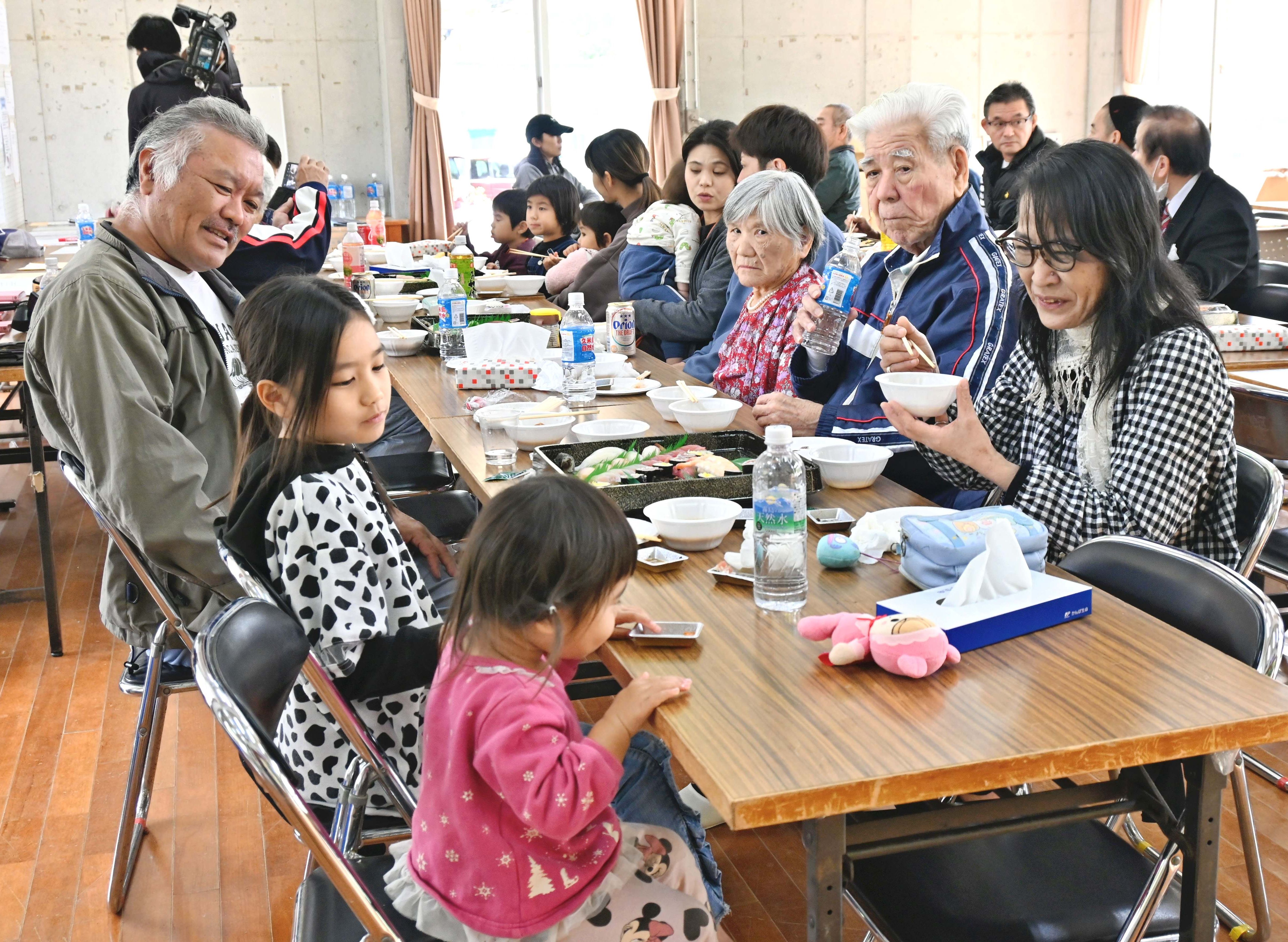 ごちそうを食べながら懇談し新年を祝う区民＝１日、国頭村の比地区公民館