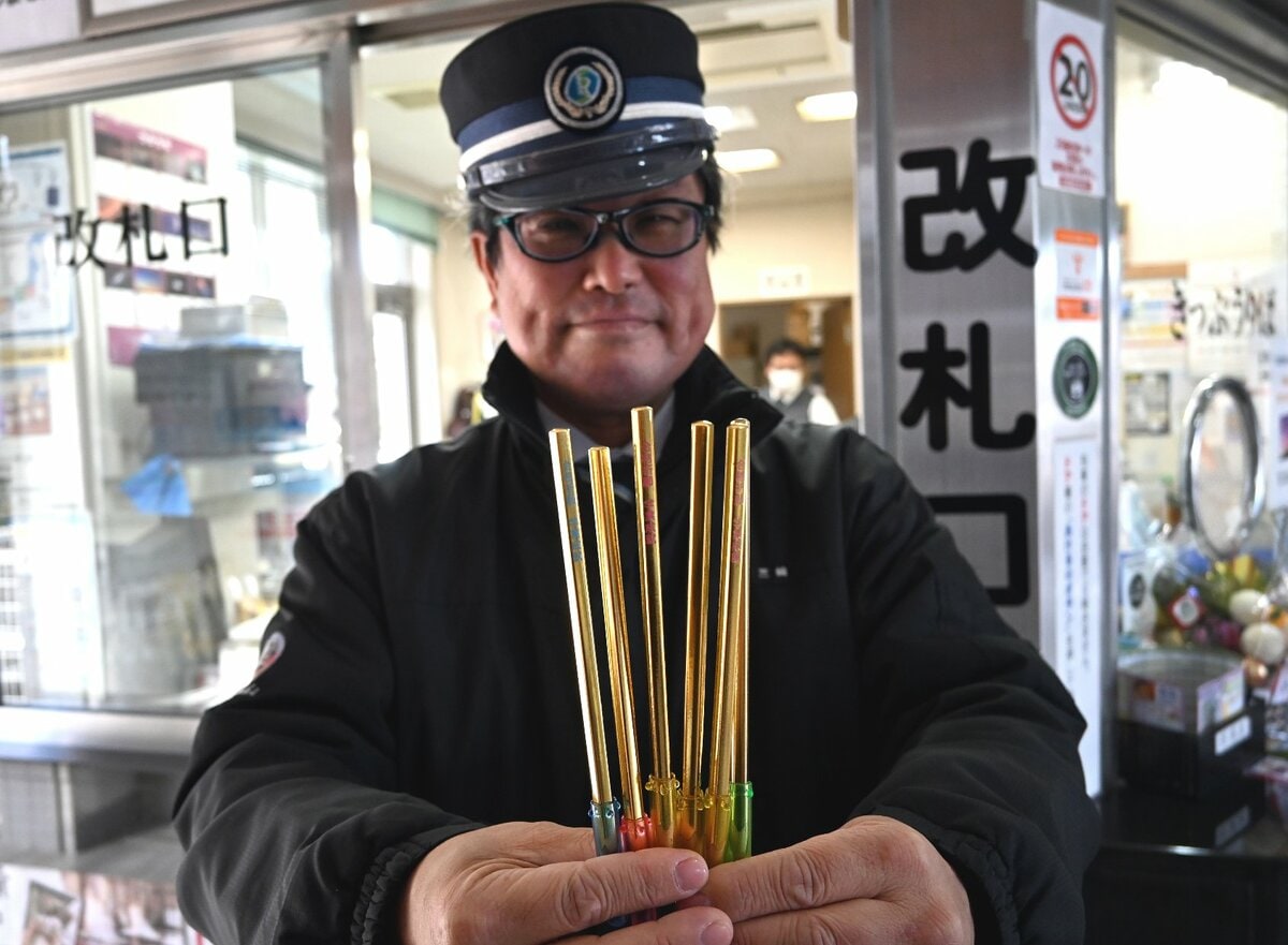 井原駅で配る「合格鉛筆」を掲げる芝崎駅長