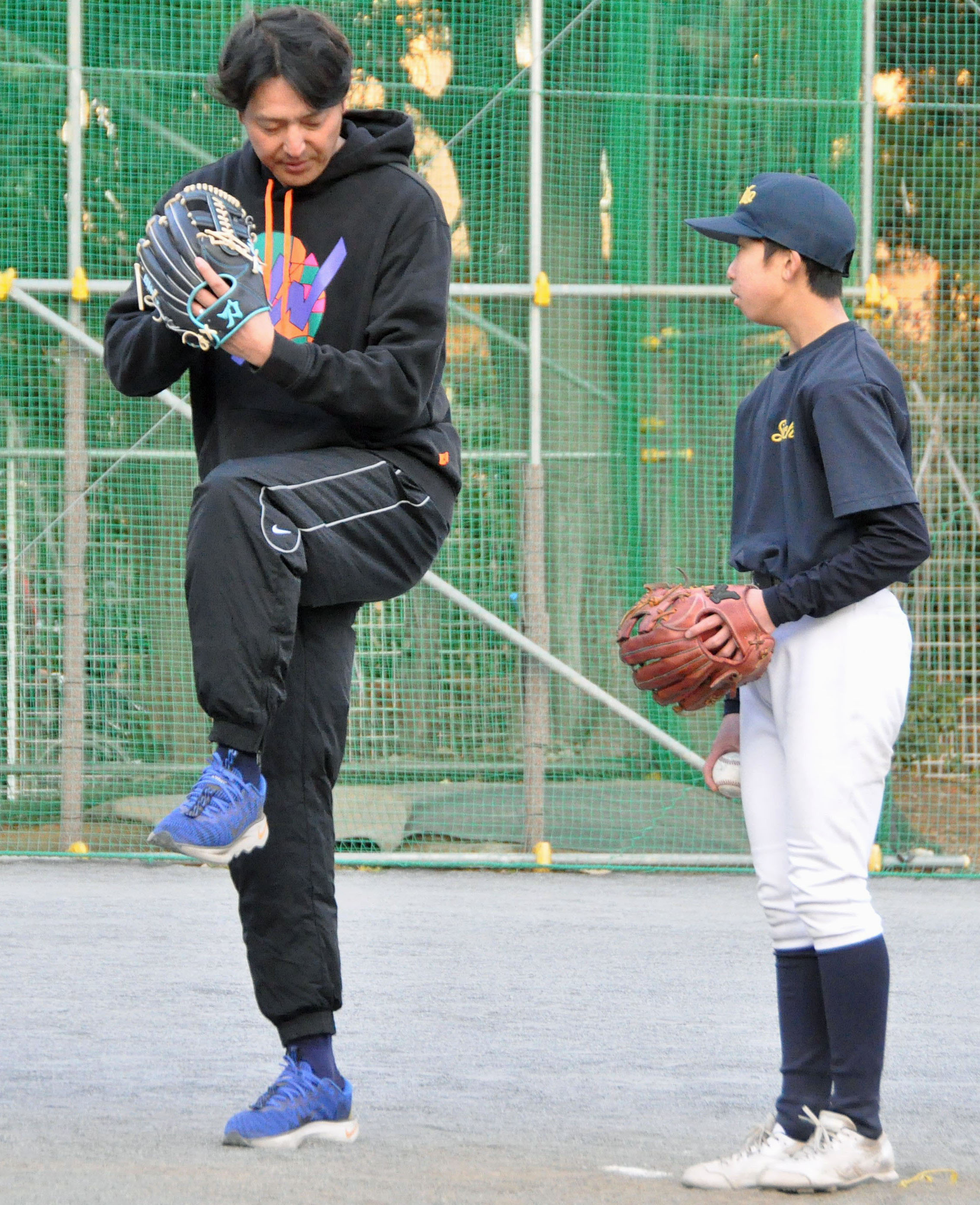 青鳥特別支援学校の生徒にアドバイスする岩隈久志さん（左）＝31日、東京都内