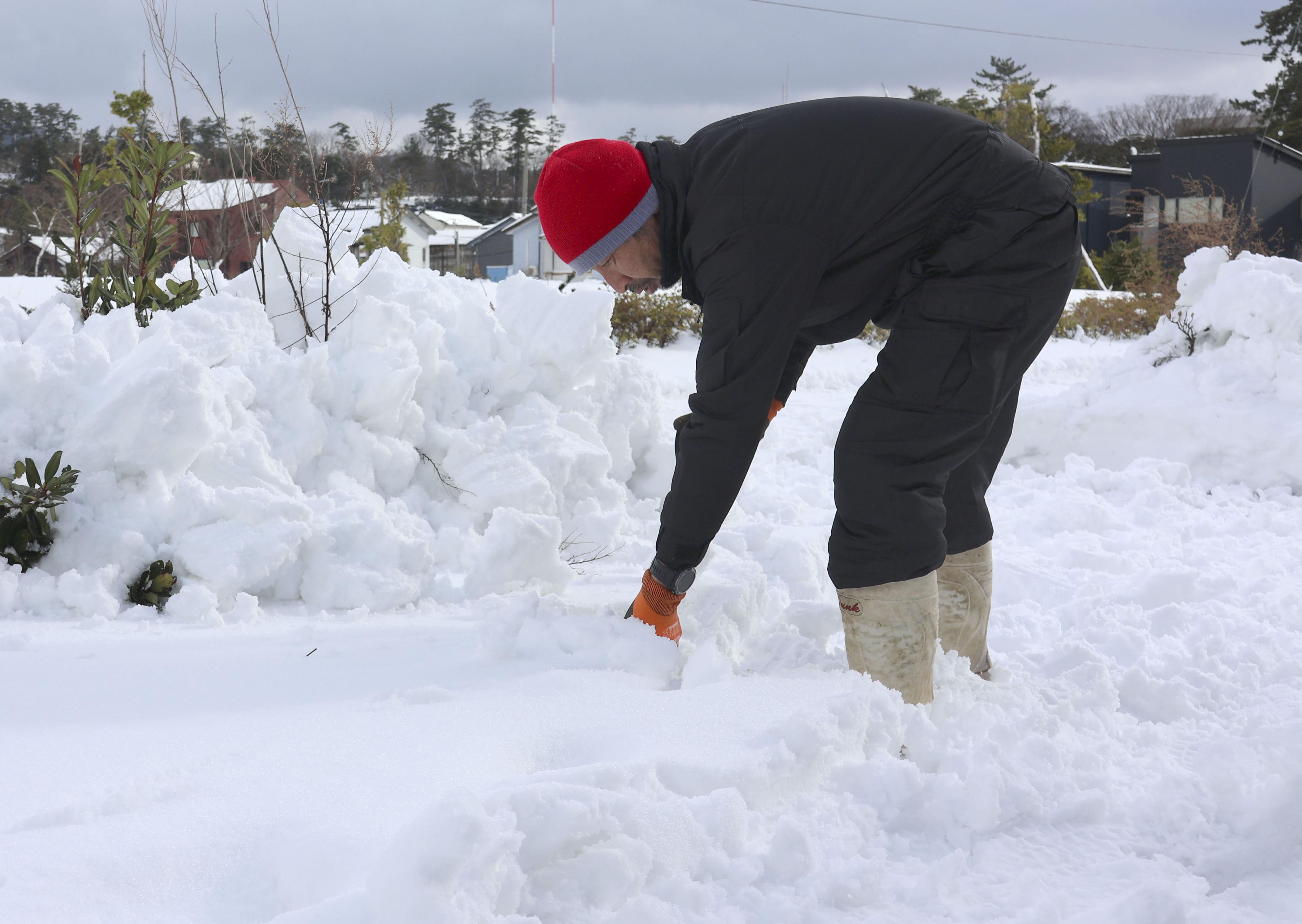 石川県輪島市の仮設住宅で、雪かきをする住民＝8日午後