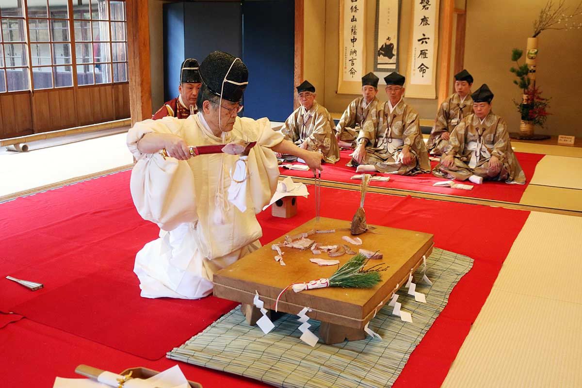 マダイをさばき、式題「宝船之鯛」を表現する刀主の田代さん＝横浜市中区の三渓園