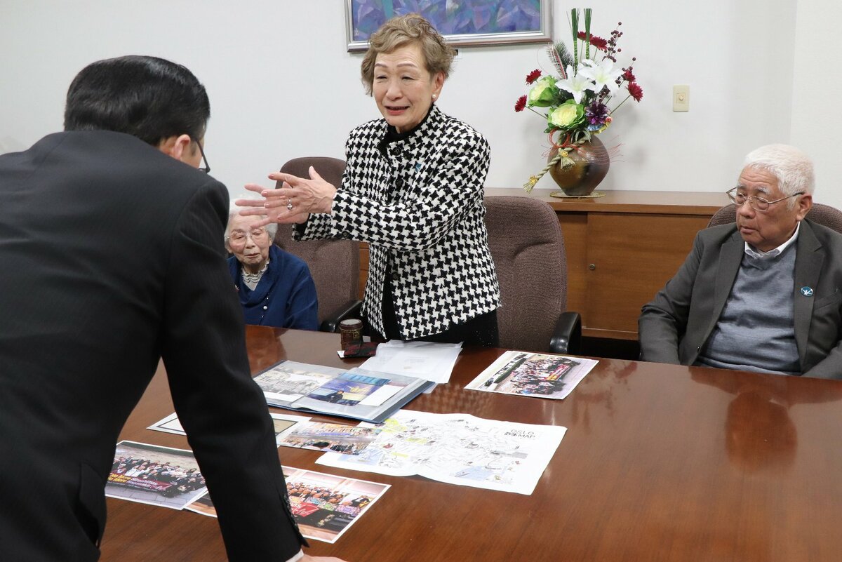 丸山知事（手前）に授賞式の様子を伝える本間会長（奥中央）