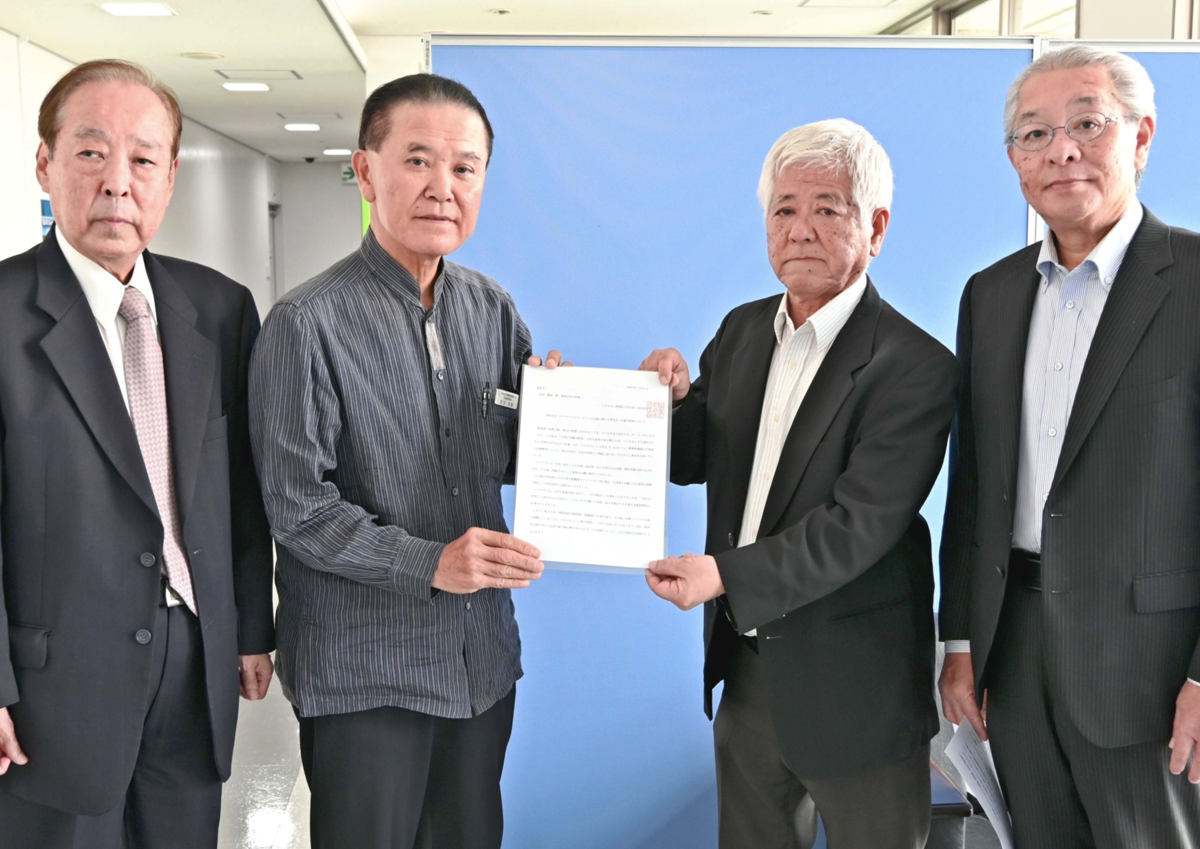 滝沢大生さんへの支援を求める要請書を「華思会」の稲福隆会長（右から２人目）に手渡す「ヒロキさん救援友の会」の前田光幸代表（同３人目）＝２１日、那覇市・沖縄産業支援センター