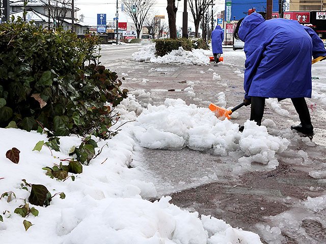 雪かきに追われる人たち＝９日午前８時１０分ごろ、射水市三ケ