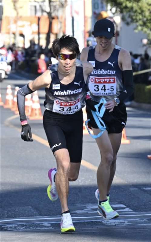 たすきを受けて走り出す西鉄6区の太田黒卓（左）