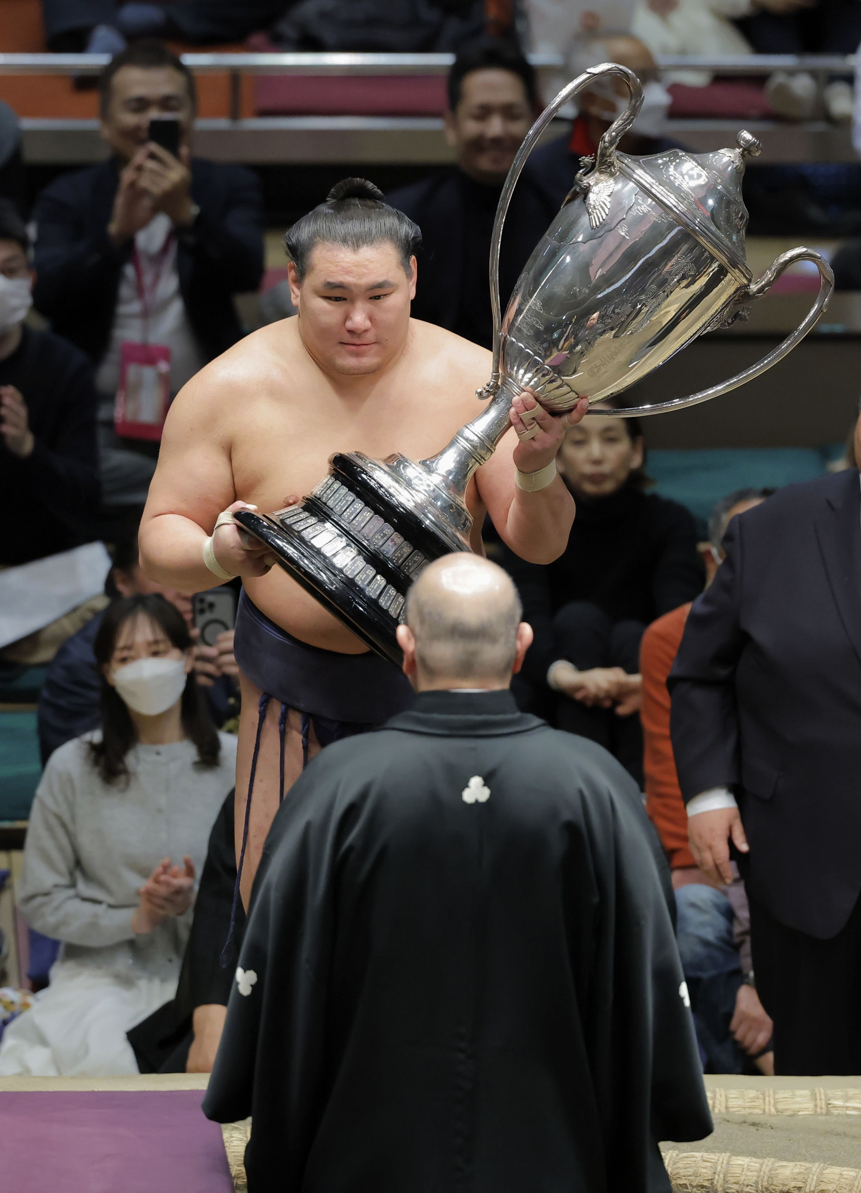 大相撲初場所で優勝を果たし、日本相撲協会の八角理事長（手前）から賜杯を受け取る豊昇龍＝26日、東京・両国国技館