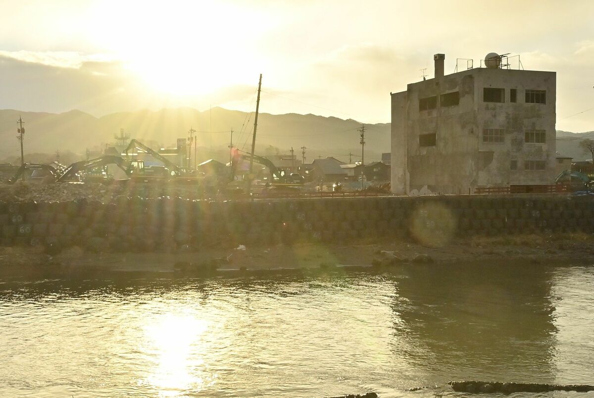 元旦の朝日に照らされる焼失した輪島朝市。たくさんの重機が置かれていた＝１日午前８時、石川県輪島市鳳至町、河野光吉撮影