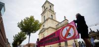 Demonstranten protestieren vor dem wiederaufgebauten Turm der Garnisonkirche in Potsdam