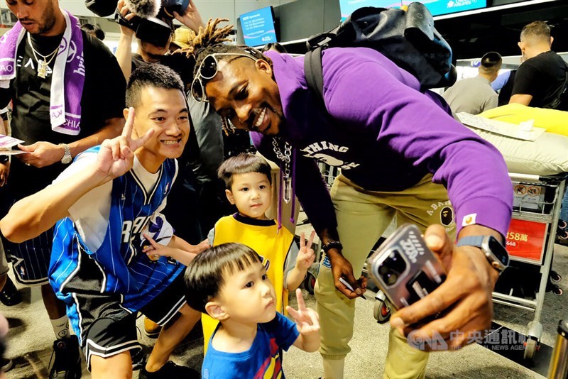 Eight-time NBA All-Star Dwight Howard (right) takes photos with fans at Taiwan Taoyuan International Airport on May 30, 2023. CNA file photo