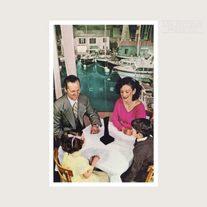 A photograph of a family sitting down at a dinner table with a black obelisk roughly one foot tall at the center of the table