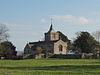 Stone building with square tower topped by a small spires.