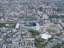 Yankee Stadium (center) and the Grand Concourse to its left. To the right of the Stadium is its former site.