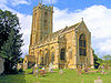 Yellow stone building with square tower.