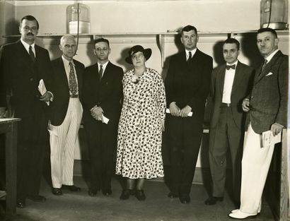 monochrome photograph of six men and a woman, standing