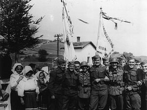 Soldiers posing next to a group of peasant women