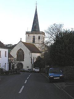 White painted church with square tower topped with a spire.