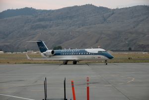 An aircraft located on a runway, with a mountain in the background.