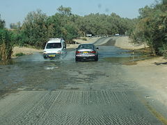 Vehicles crossing a modern ford over a creek