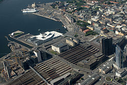 Aerial photo of Sentrum. The centre is located on the bottom-right side of the picture and the Waterfront with the Opera is located near the top. On the left side of the picture is Barcode. In the middle of the picture is the railway lines with the Oslo Central Station.