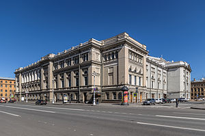 A very large, three-story tall stone building in early 18th-century style, with many narrow windows