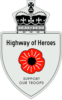 A Highway of Heroes reassurance marker with a red poppy flower in place of a number. Above that is the text Highway of Heroes, and below it SUPPORT OUR TROOPS.