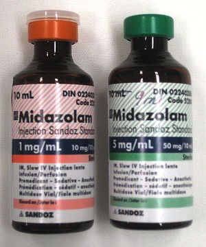 Two 10-ml bottles labeled Midazolam  - the bottle on the left has a label in red and says 1 mg/ml; the one on the right is in green and says 5 mg/ml. Both bottles have much fine print.