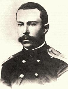 A young man with a full but neatly trimmed moustache, wearing a dark naval uniform