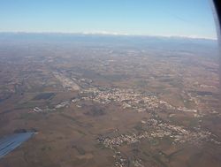 Aerial view of Cervignano and Terzo di Aquileia; the Alps in the background.