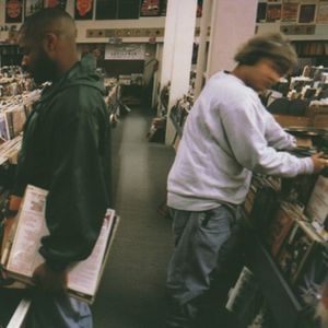 Two men look through vinyl albums at a record store.