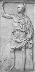 A monochrome relief stele depicting a man in classical Greek clothing raising one arm