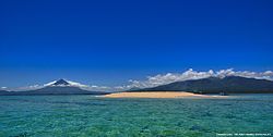 The foreground is the Corangon shoal, made up of mainly crushed corals and white sand, which is about 15 minutes boat ride from the shore of Brgy. Baybay. Mt. Mayon (left), Mt. Masaraga (center) and Mt. Malinao (right) serve as the background. The entire municipality of Tiwi is located at the north-eastern side of Mt. Malinao.