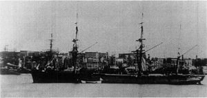 A three-masted ship with dark sides and a flared prow