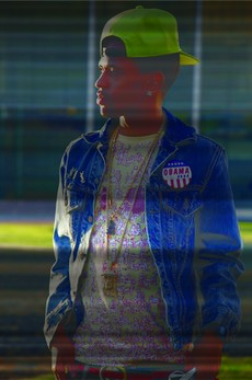 Side profile of a man wearing a denim jacket and a cap