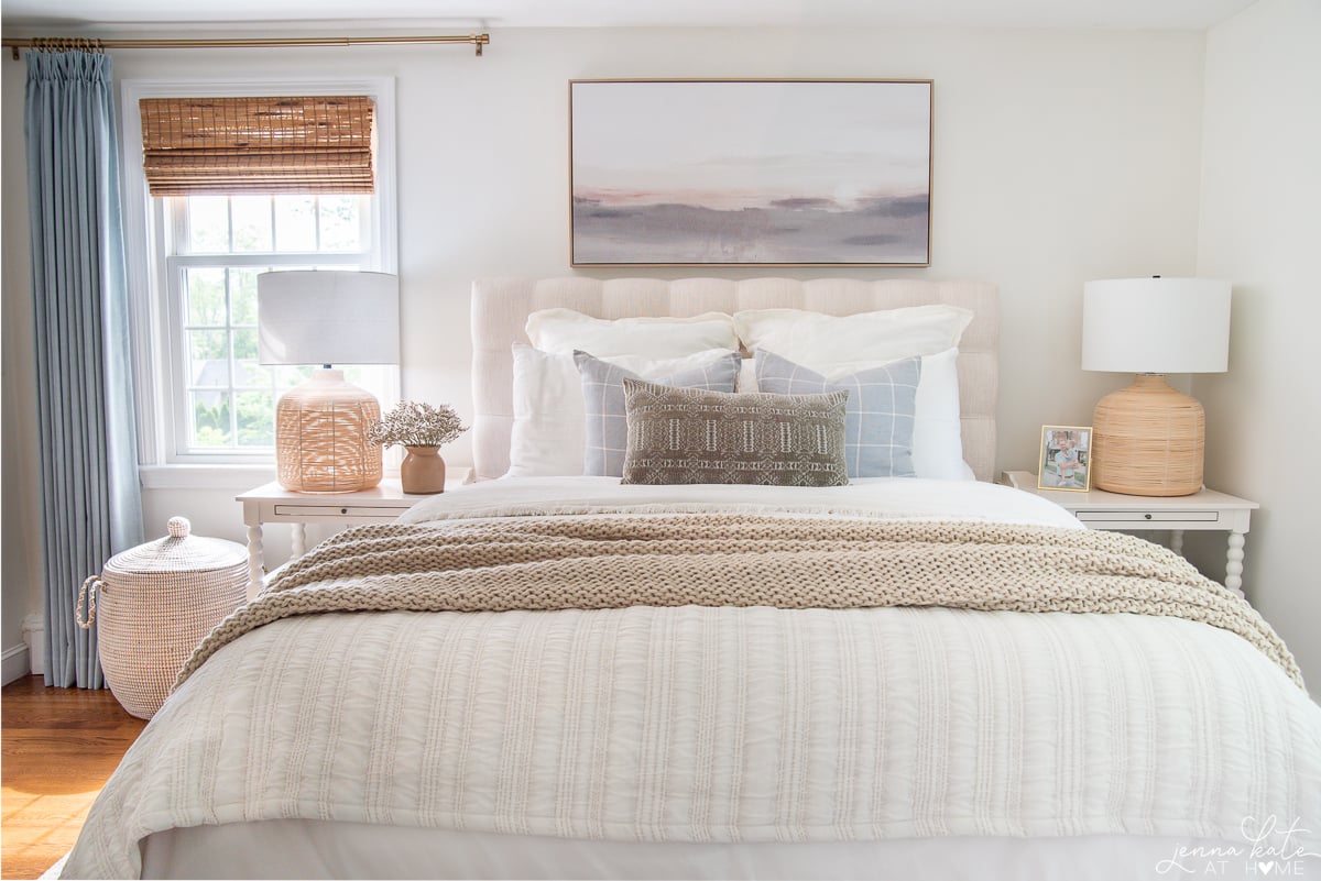 bed with blue pillows and artwork over the headboard