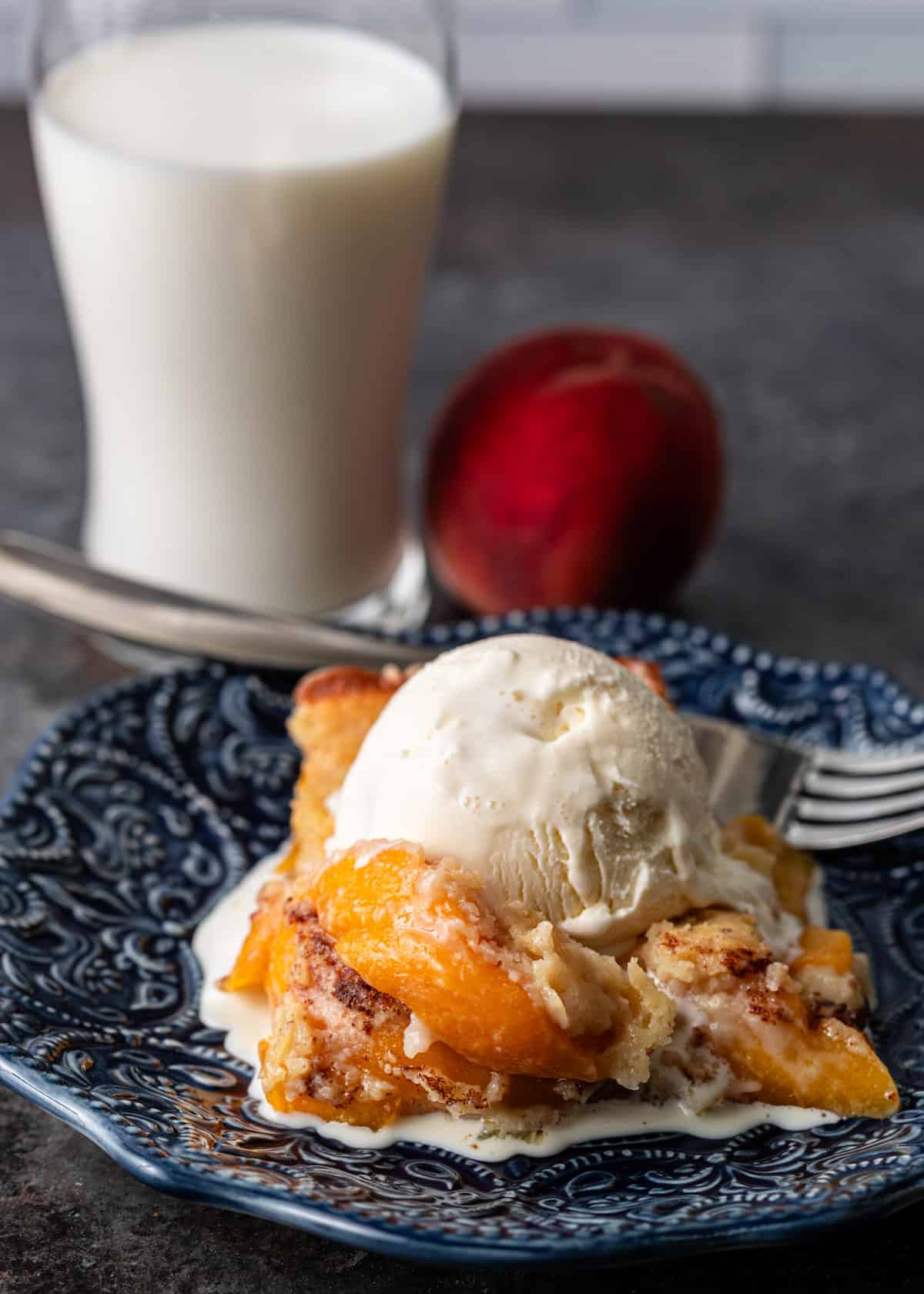 a slice of peach cobbler with vanilla ice cream on top