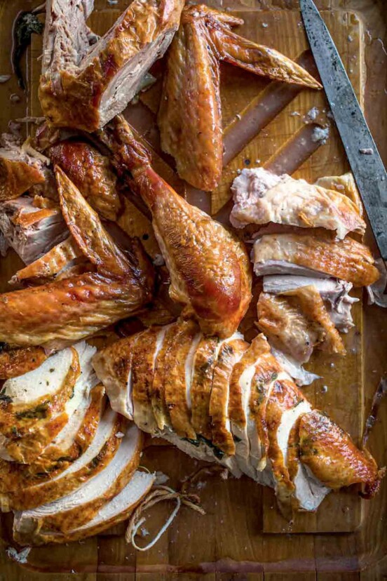 A carved turkey on a wooden cutting board.