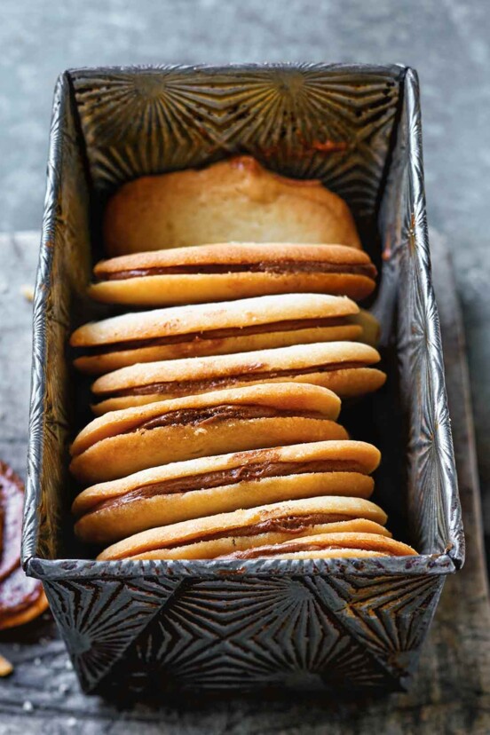 Eight homemade Milano cookies in a metal loaf tin.