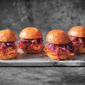 A marble slab with 4 vegetarian sloppy Joe sliders.