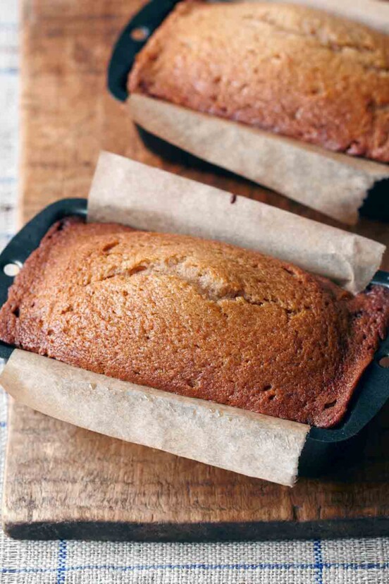 A loaf of applesauce bread in a parchment-lined loaf pan.