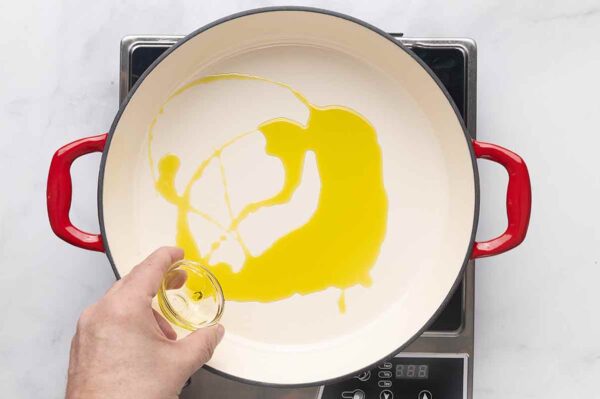 Olive oil being poured into a skillet.