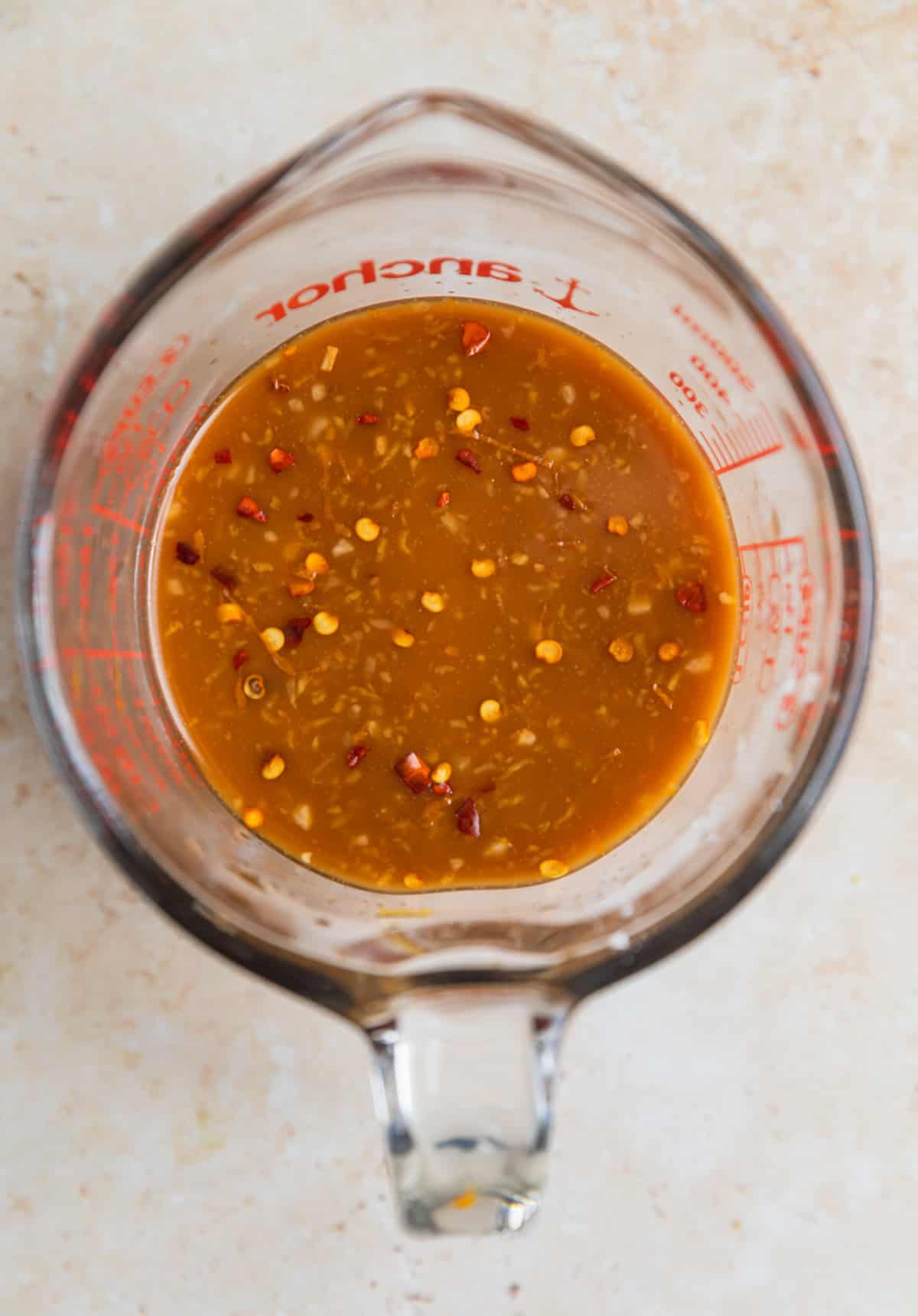 Whisked teriyaki sauce in glass measuring cup.