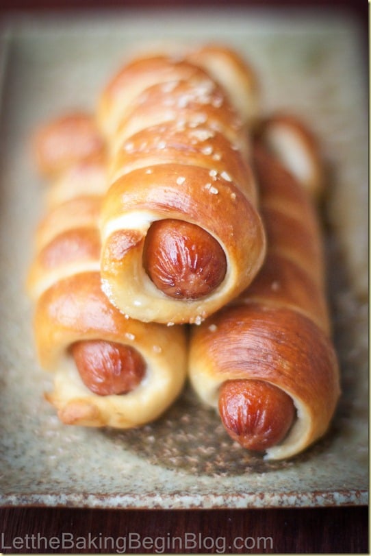 Pretzel Dogs stacked on top of each other topped with salt.