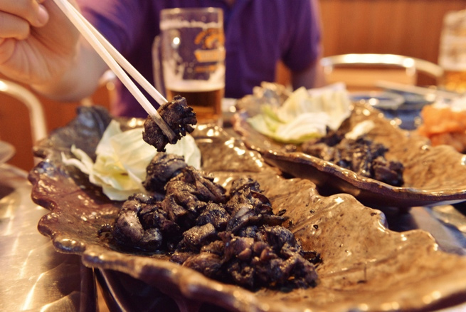 焼き鳥を箸で持ち上げている写真