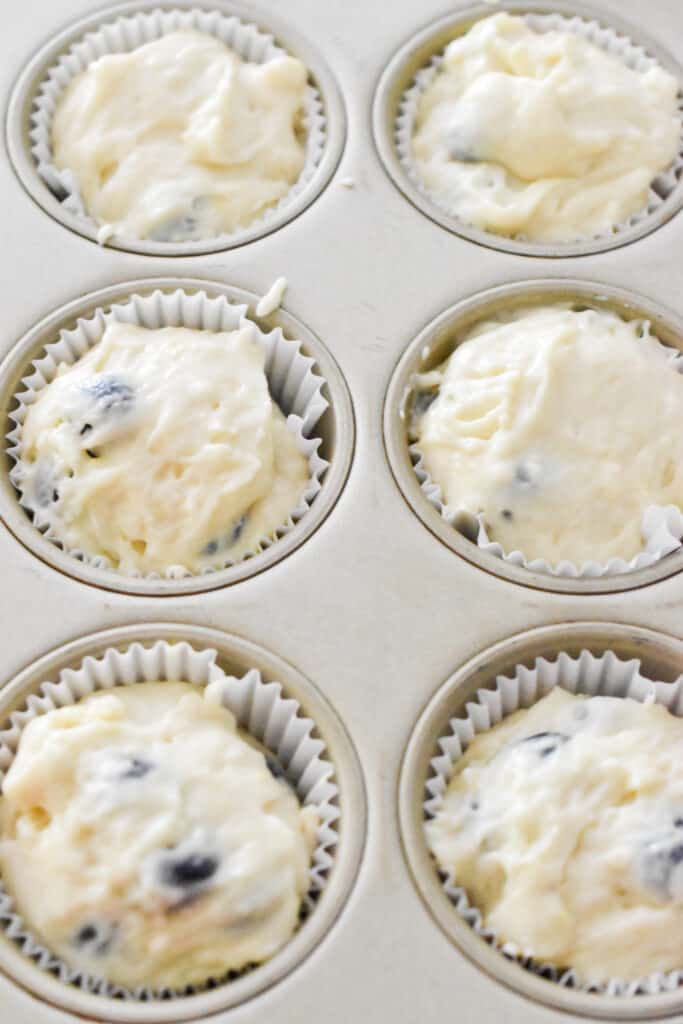 The muffin batter is scooped into the muffin tins.