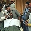 MICHAEL EALY (Ricky), TROY GARITY (Isaac), and LEONARD HOWZE (Dinka) look on (center left to right) while CEDRIC THE ENTERTAINER (Eddie, far left) gives a shave 