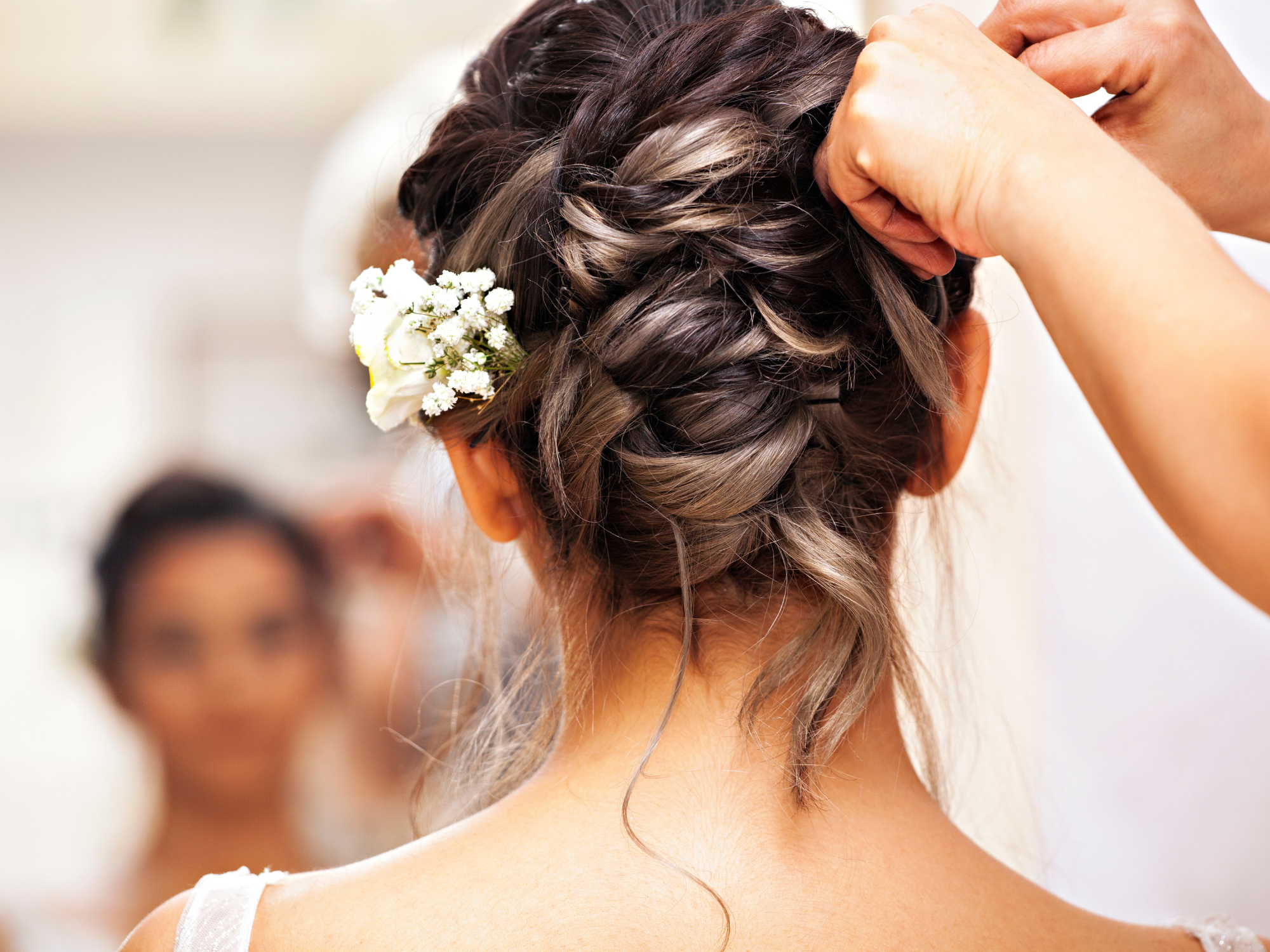 Bride getting her hair styled on wedding day