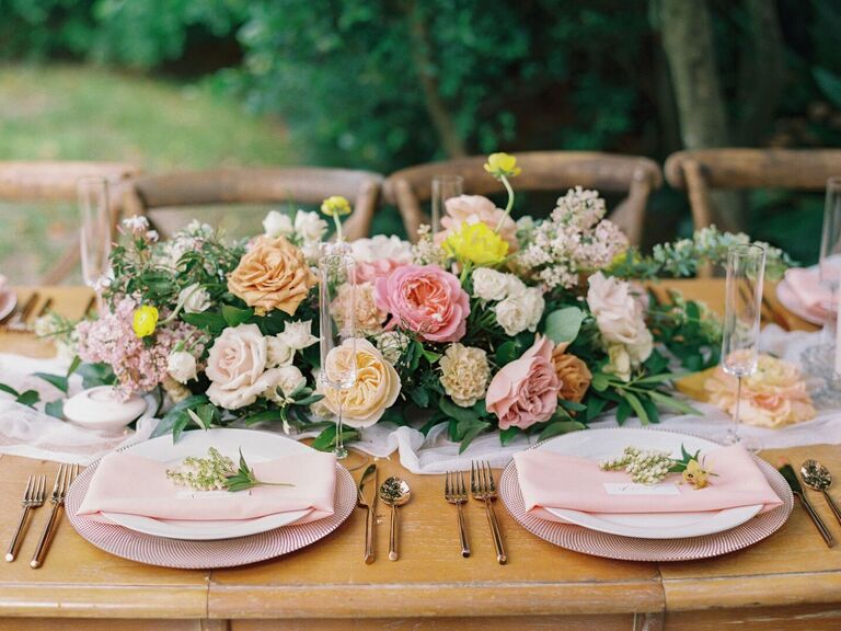 romantic garden style wedding centerpiece with blush, pink yellow roses and greenery