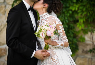 Bride wearing high neck wedding dress with low bun updo