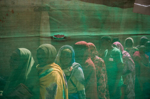 Survivors queuing at a border crossing point between Sudan and Chad where more than 600,000 people have fled in search of safety