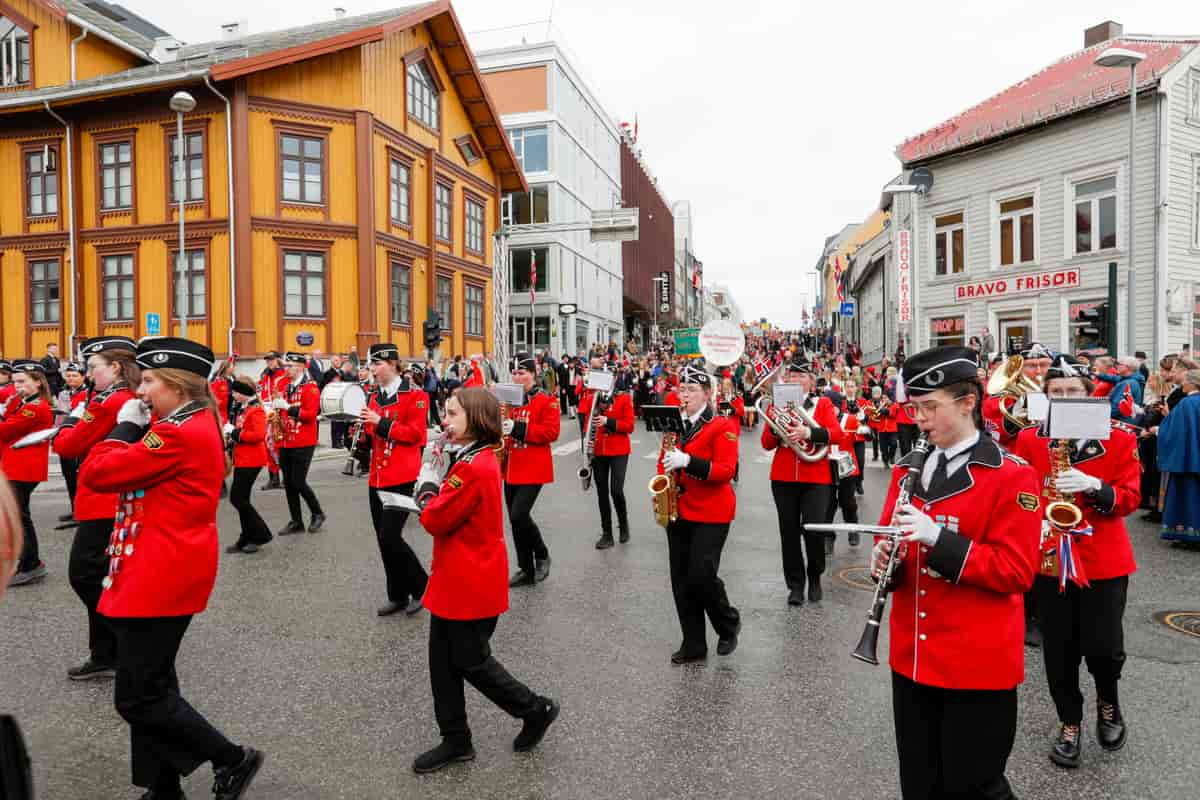 Korps med røde jakker og svarte bukser og båtluer. 